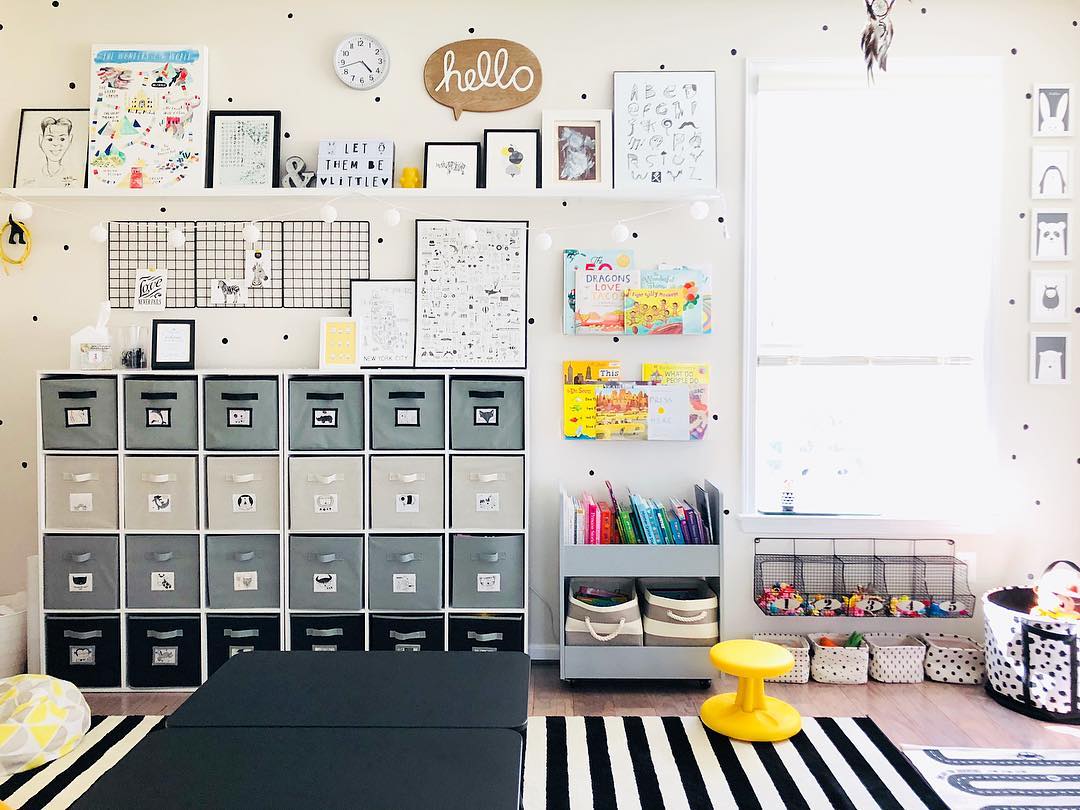 Grey, white, and black storage cube in room with kids art. Photo by Instagram user @elizabethcancaan