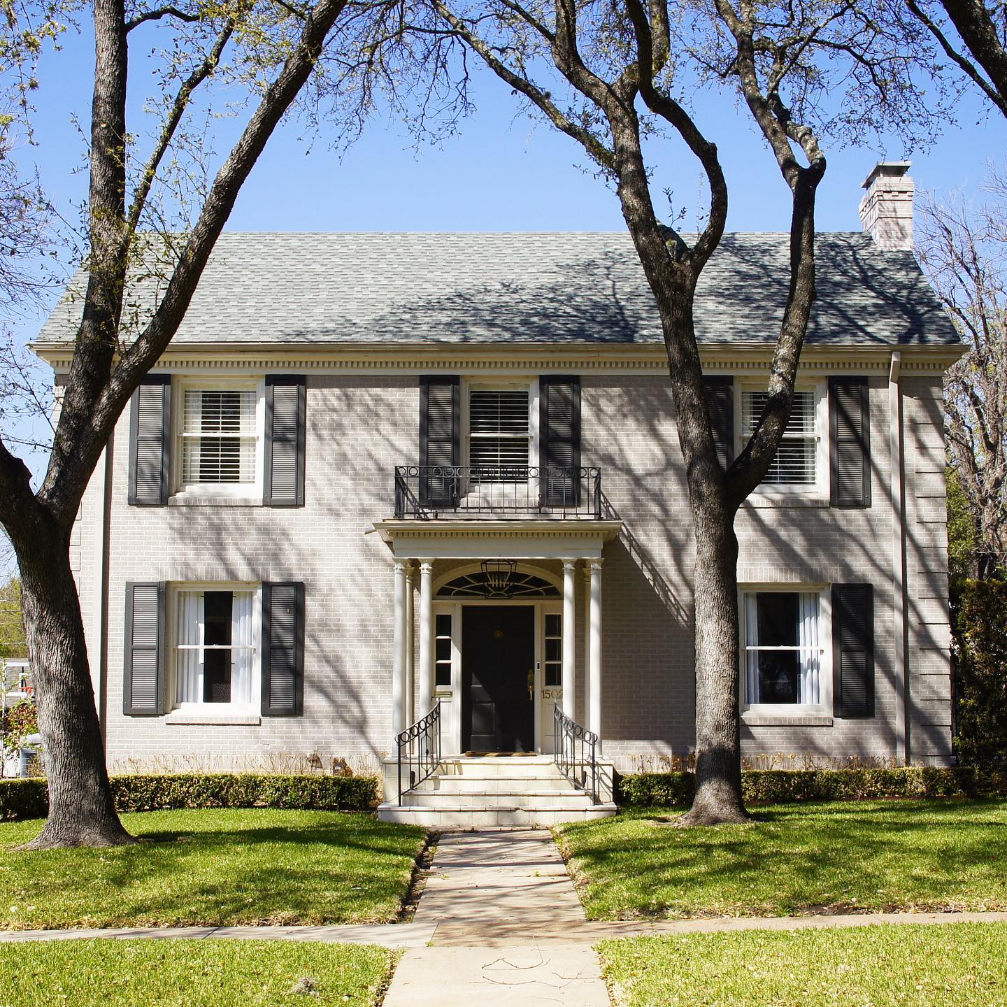 gray colonial revival style home with columns and shutters. photo via @organicgardendreams