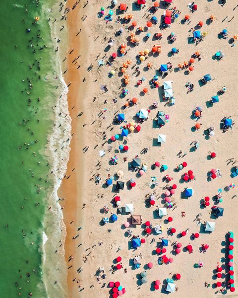 overhead shot of beach with colorful umbrellas and ocean photo via @cstone710