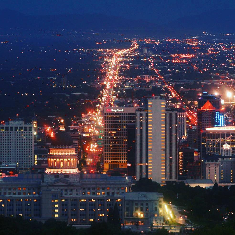 Aerial view of Salt Lake City skyline lit up at nighttime. Photo by Instagram user @daviesworldtravel