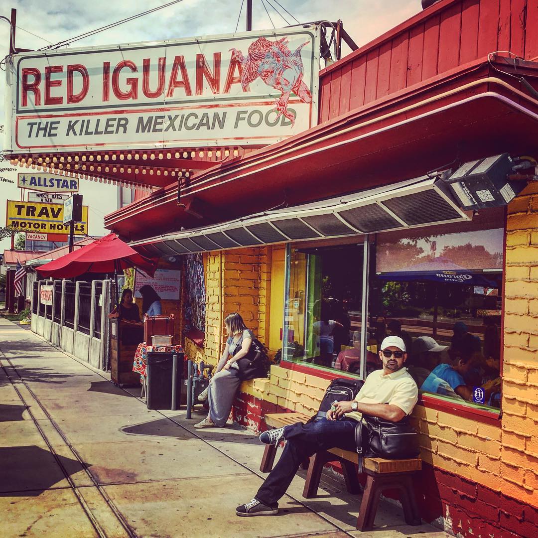 Man sits outside on a bench next to a mexican restaurant. Photo by Instagram user @adrian_eltitan