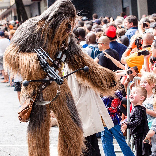 Man dressed as Chewbacca walks through parade as kids watch. Photo by Instagram user @dragoncon