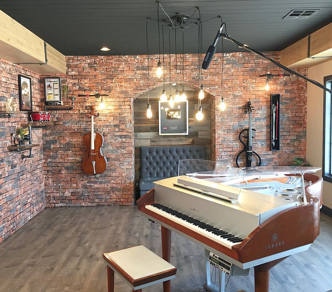 home recording studio with brick walls and piano in the middle of the room photo by Instagram user @tracibdesign