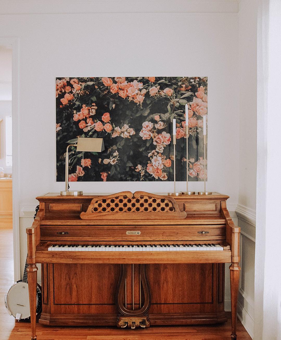 small music nook with stand up piano and art on the wall photo by Instagram user @inhonorofdesign