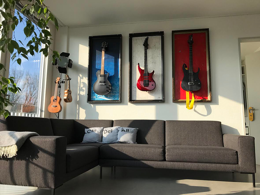 guitars placed in different colored frames as wall decor photo by Instagram user @gframes_guitardisplay