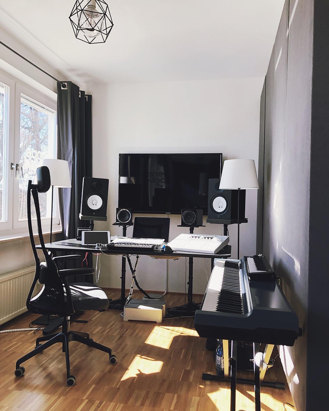 Home music studio with computer on wall and dark soundproof dividers photo by Instagram user @dopesoundstudio
