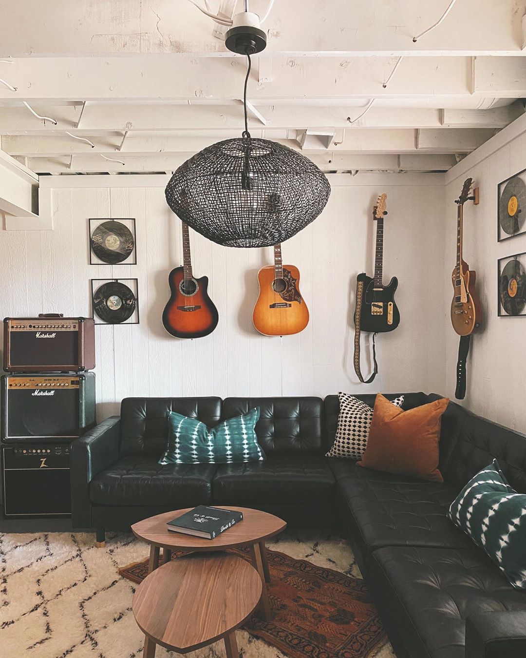 music room in home set up with large seating area and instruments on the wall photo by Instagram user @designandcaroline
