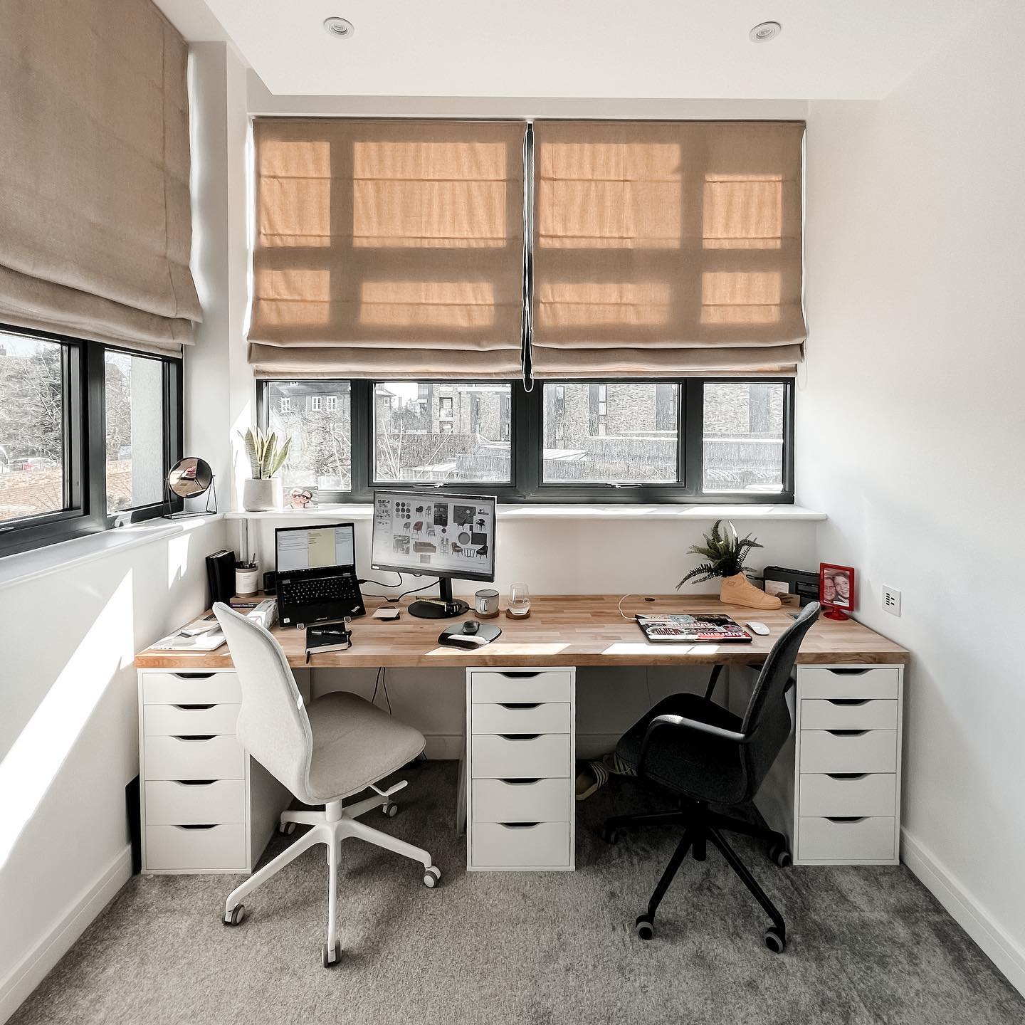 A well-lit office space with a double desk and two offcie chairs. @thatlibbygirl