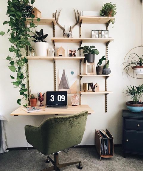 A vertical desk with several wooden shelves, adorned with deocrations, and plants, and one shelf dedicated for a laptop computer work space. @norwegianwoodonline