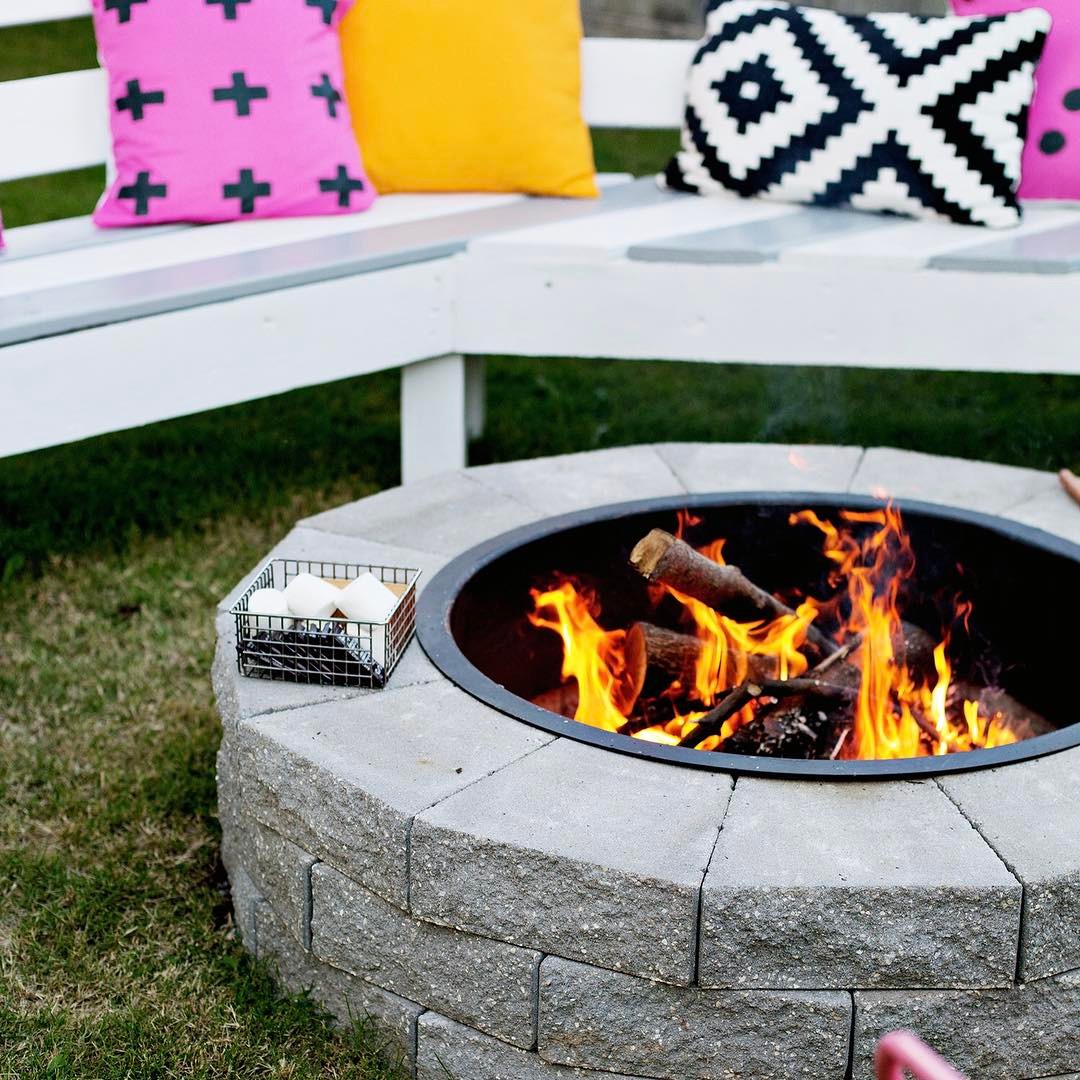 Stone fire pit surrounded by bench. Photo by Instagram user @katrinacanerealtor