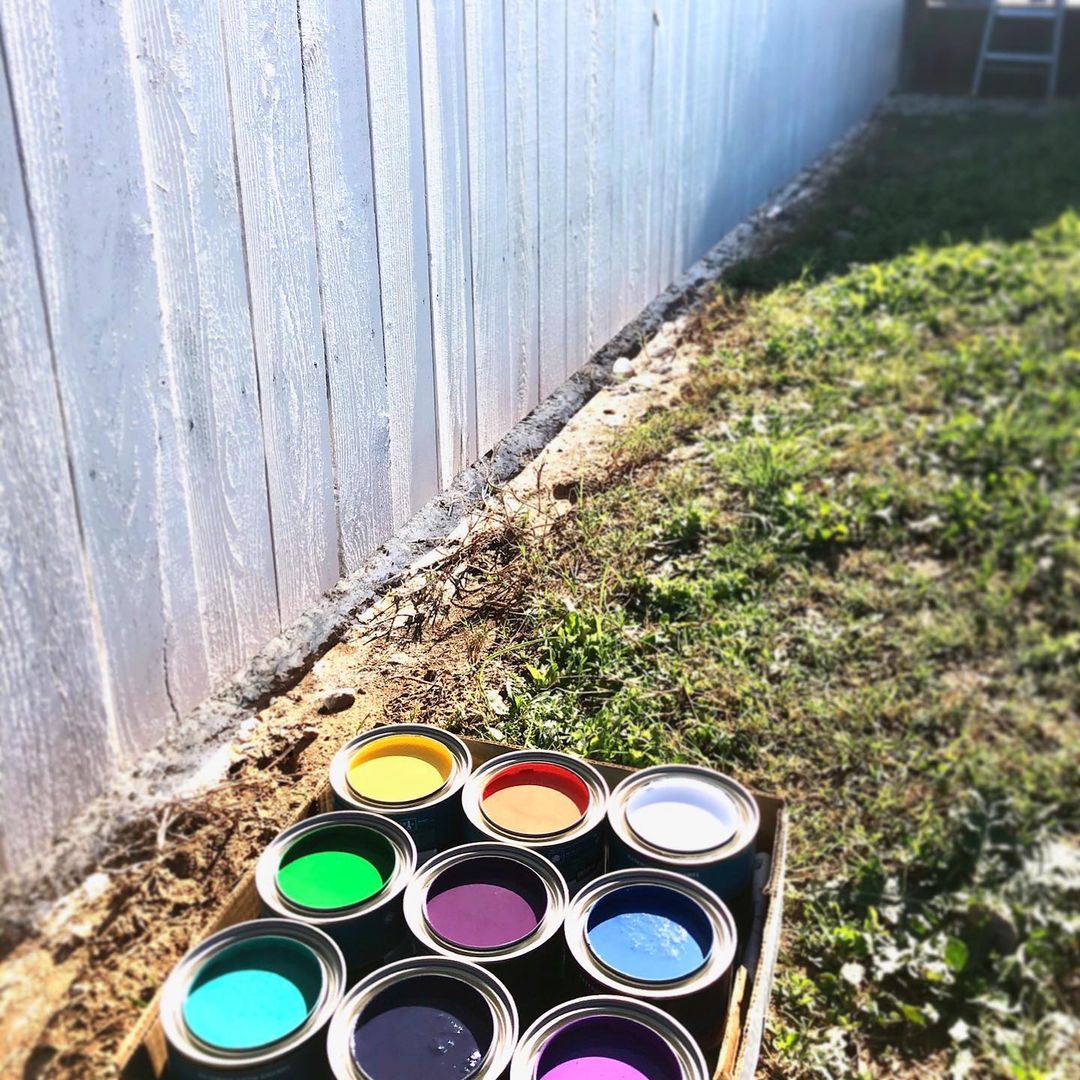 Primed Fence with Small Paint Cans In front of It. Photo by Instagram user @watsonmurals