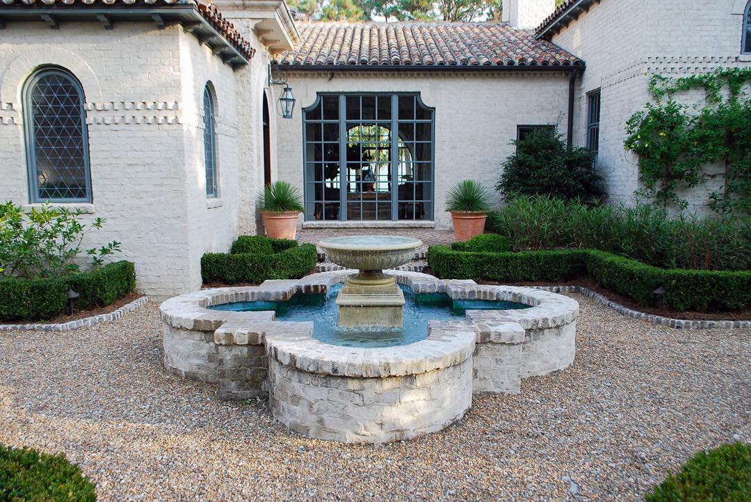 Giant white fountain in a home courtyard. Photo by Instagram user @alexsmithgardendesign