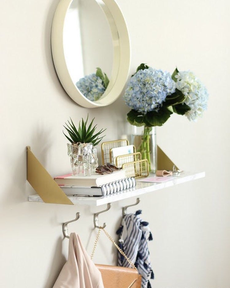 Floating shelf with hooks and mirror in apartment entryway. Photo by Instagram user @@medallion_corp