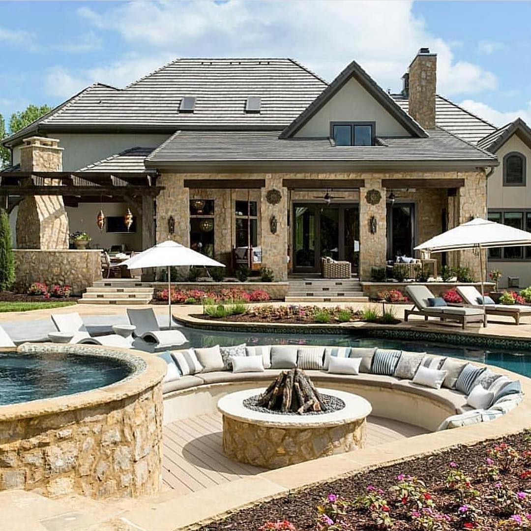 Fire pit attached to an outdoor pool and hot tub. Photo by Instagram user @starrsellshomes