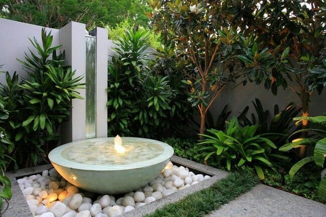 Bowl fountain with light on it surrounded by rocks. Photo by Instagram user @californiawaterscapes