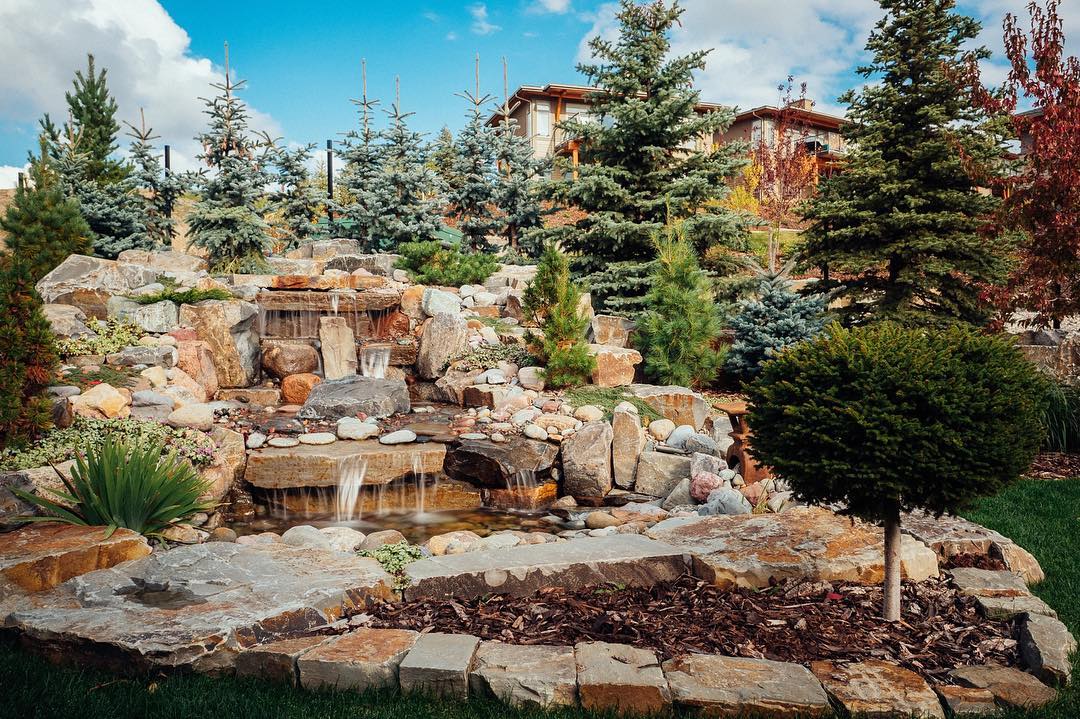 Giant rock fountain mixed in with the landscape. Photo by Instagram user @waterbydesign