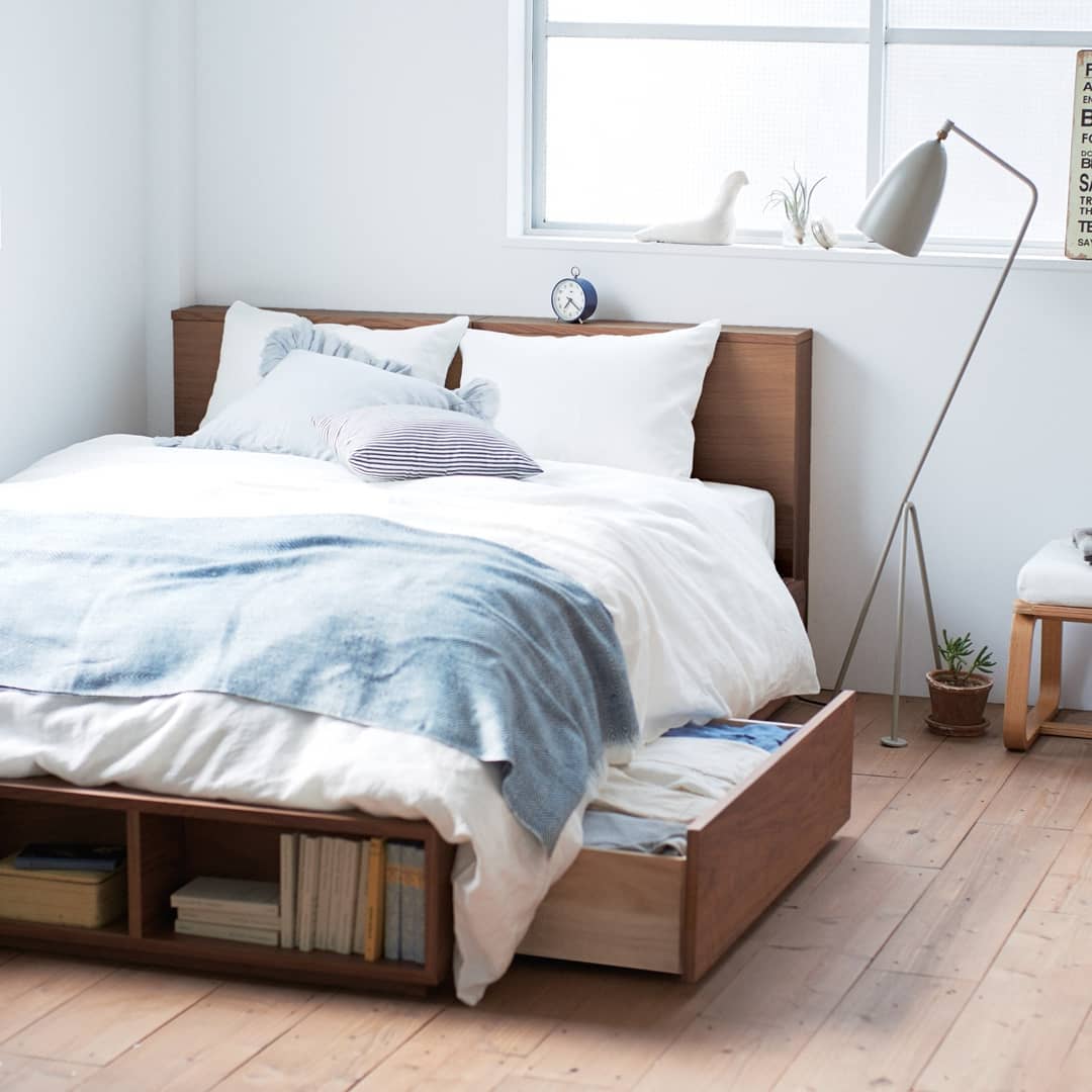 Platform bed with storage drawers in minimalist apartment. Photo by Instagram user @mujigermany