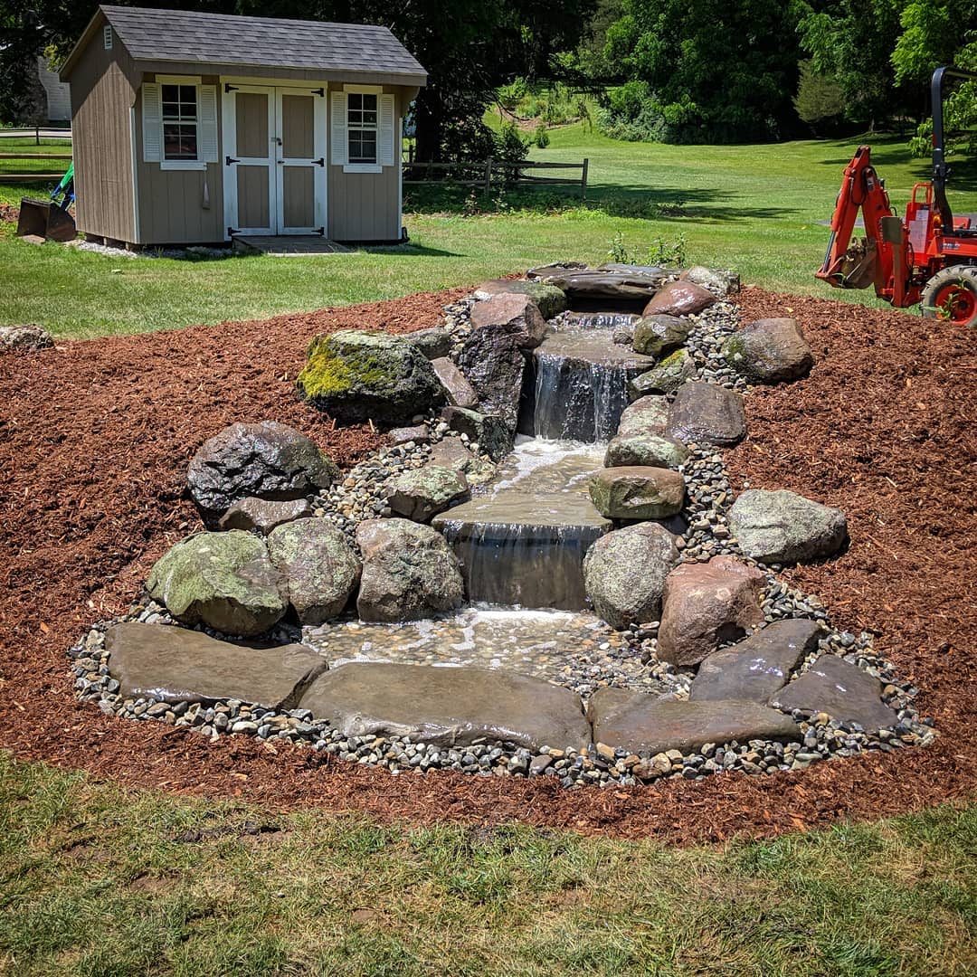 Pondless rock waterfall in the middle of backyard. Photo by Instagram user @aquaterraearth 