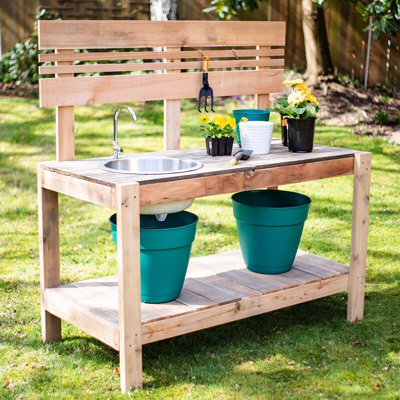Wooden potting bench with blue pots on it.
