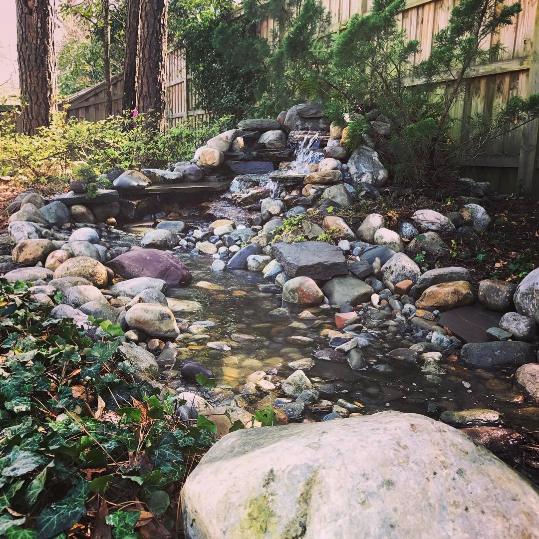 Small rock waterfall in a backyard. Photo by Instagram user @creativecascades