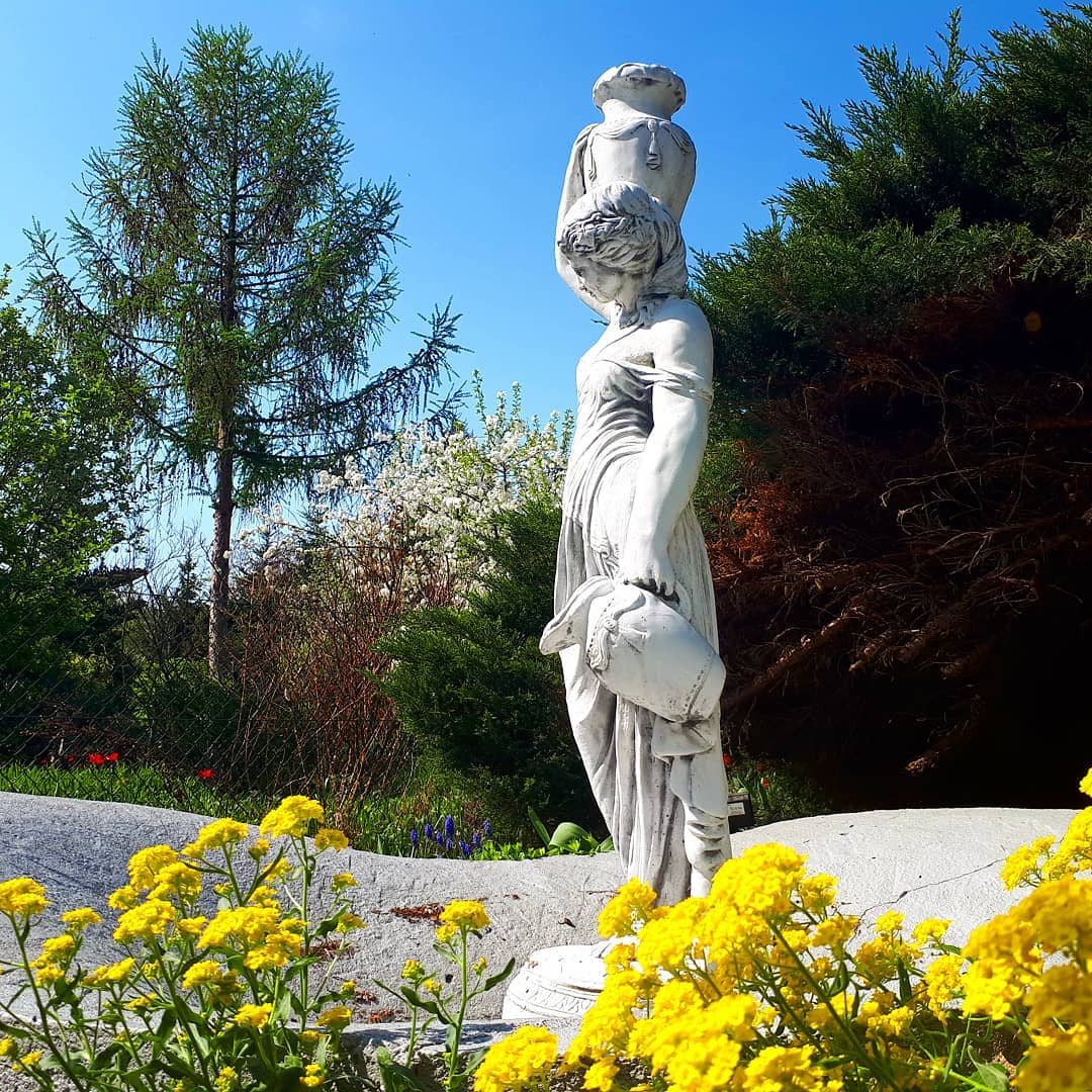 White statue fountain of woman in garden. Photo by Instagram user @agulinda68