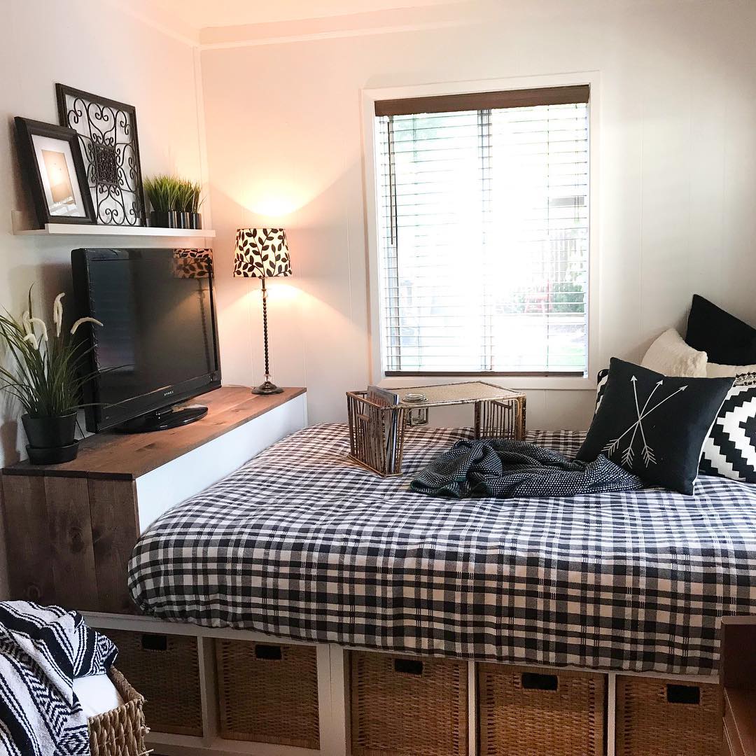 Studio apartment bed with footboard for TV storage. Photo by Instagram user @urbancottageliving