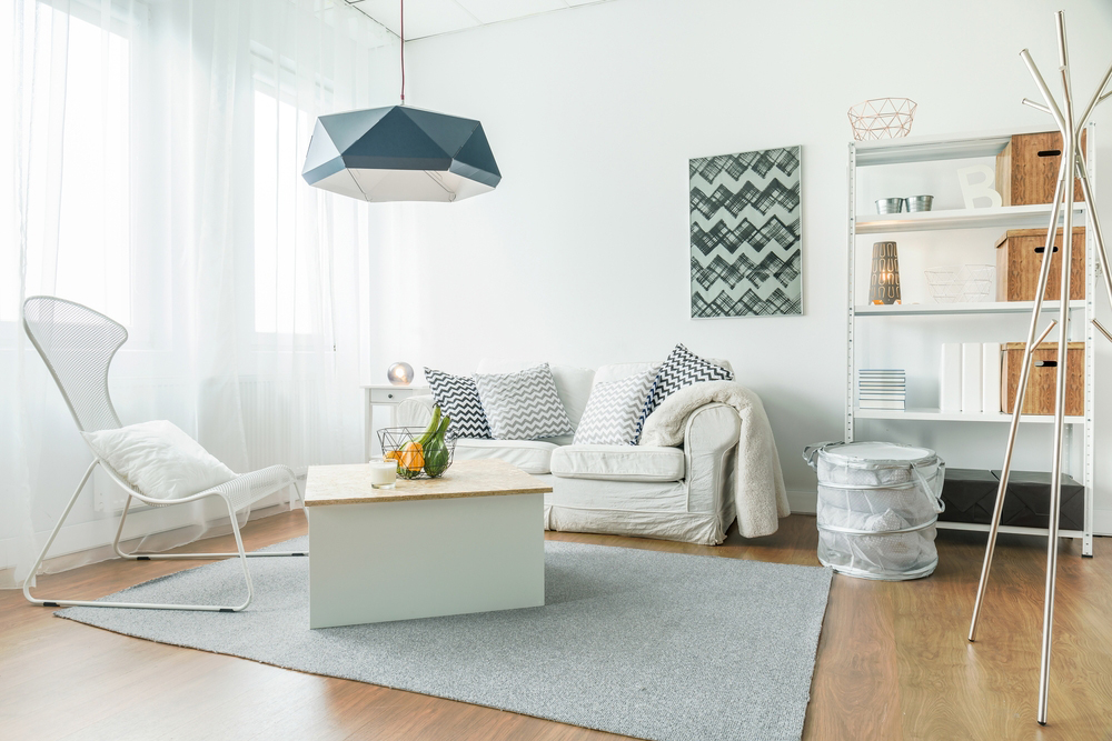 small living room inside a studio apartment with small love seat and chair