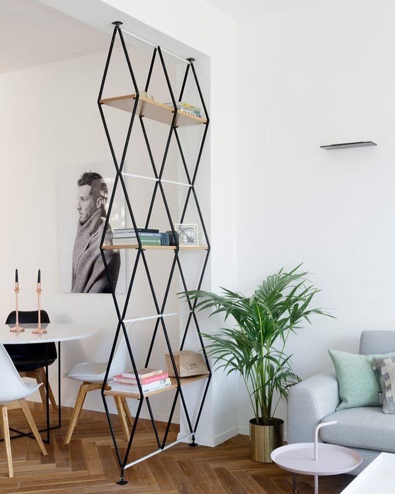 Open room divider with storage shelves for studio apartment. Photo by Instagram user @_metals