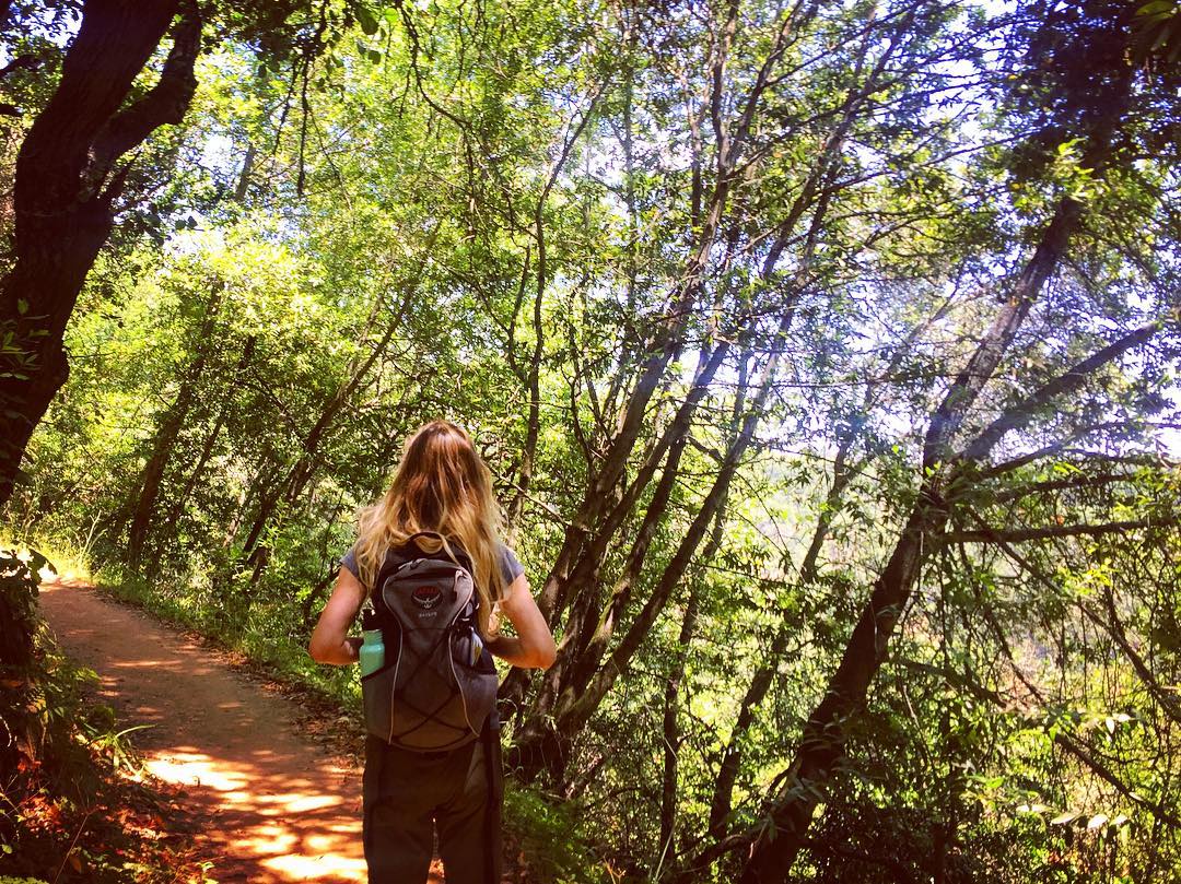 young girl with a backpack walking on a nature trail photo by Instagram user @matirose