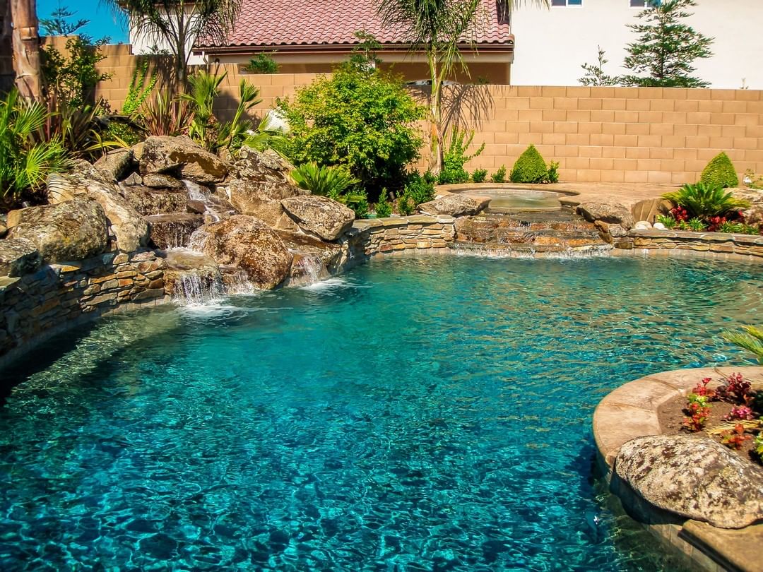 Outdoor swimming pool with rock water fall. Photo by Instagram user @vineyardpools