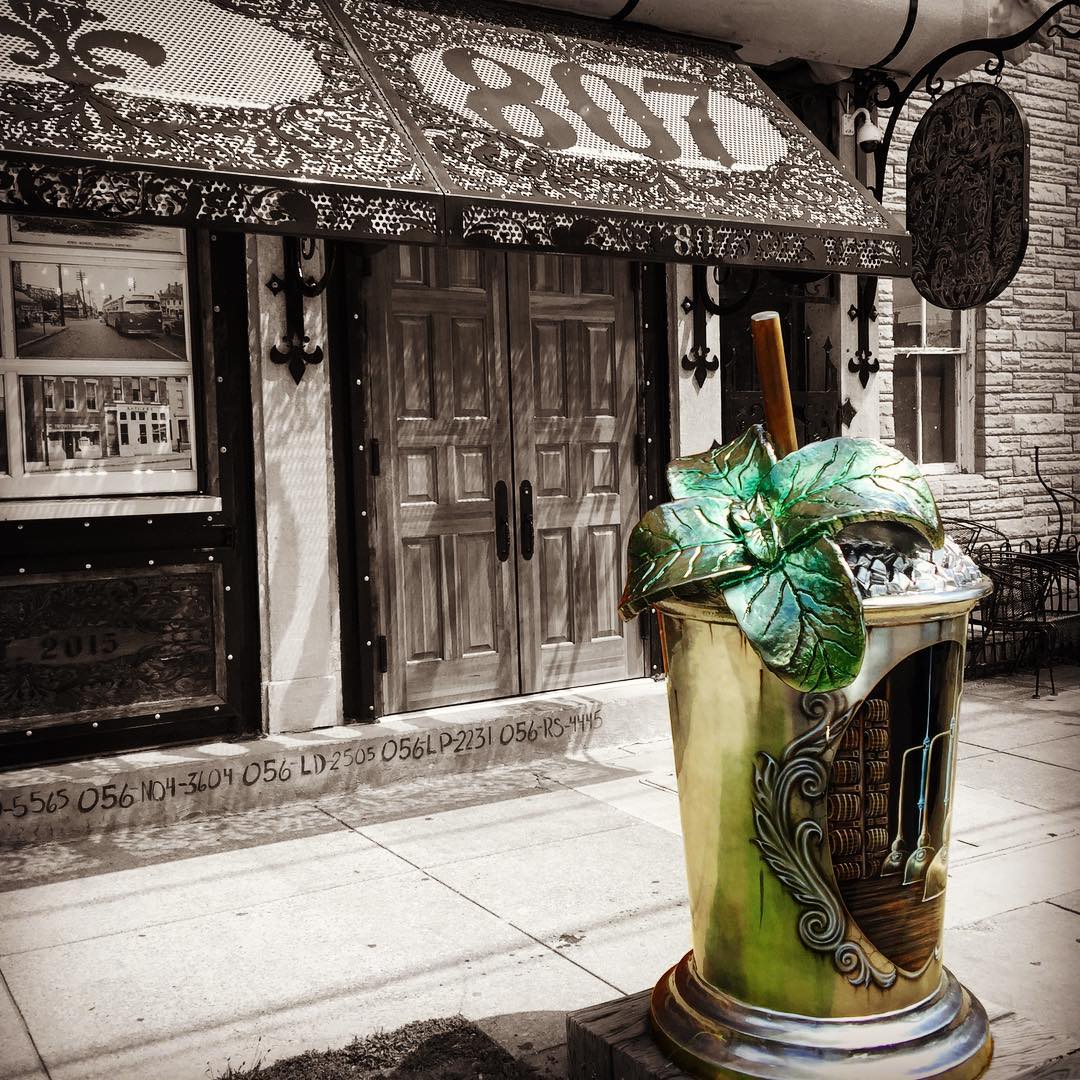 Outside street view outside of TAJ Louisville with a statue of a mint julip. Photo by Instagram user @tajlouisville