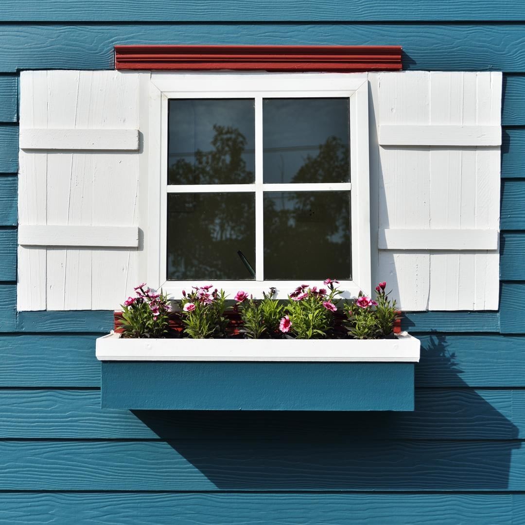 Window boxes outside blue house. Photo by Instagram user @nationalhrdware