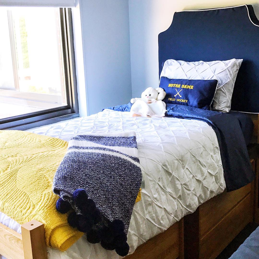 College Dorm Room Bed with Blue & Yellow Throw Blankets. Photo by Instagram user @fourteenth_floor