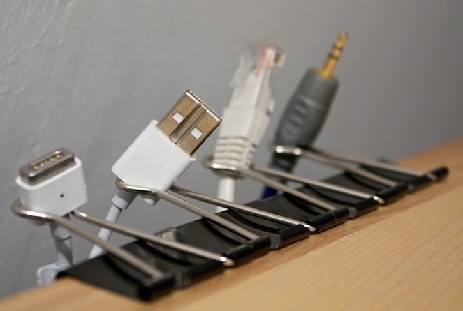 Binder clips on edge of furniture to hold phone chargers. Photo by Instagram user @bycherished