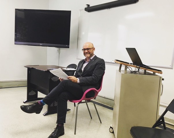Professor Sitting in a Chair at Marymount Manhattan College. Photo by Instagram user @ewlmmc