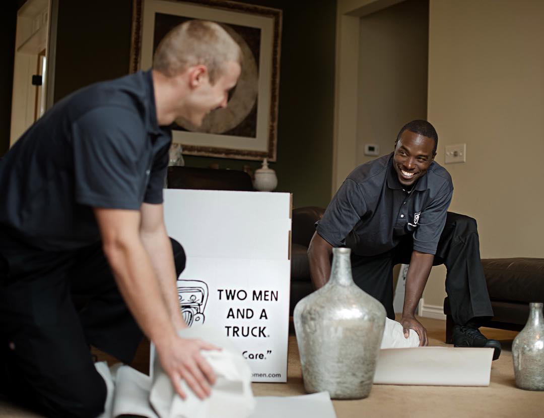 Professional Movers Packing Vases and Other Objects in Living Room. Photo by Instagram user @twomenandatruck