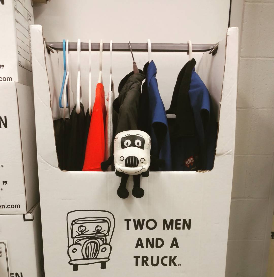 Clothes in Boxes Hanging from Hangers. Photo by Instagram user @twomenandatruck_grnorth