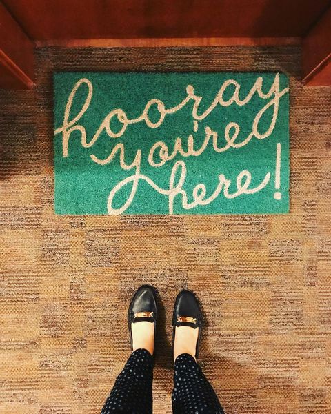 Green welcome mat with 'hooray you're here!" Photo via @mckenzie.apartment.company