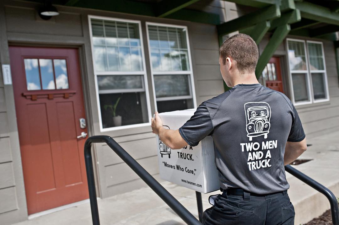 Professional Mover Carrying a Box into a House. Photo by Instagram user @twomenandatruck