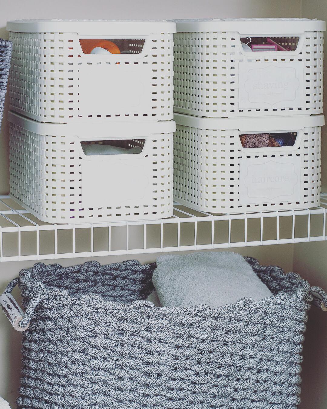 Plastic organizer totes on wire closet shelving. Photo by Instagram user @straightened_spaces