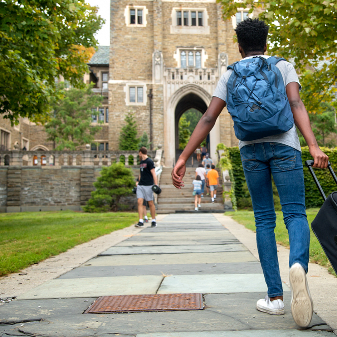 College Student Wheeling Bag onto College Campus. Photo by Instagram user @cornelluniversity
