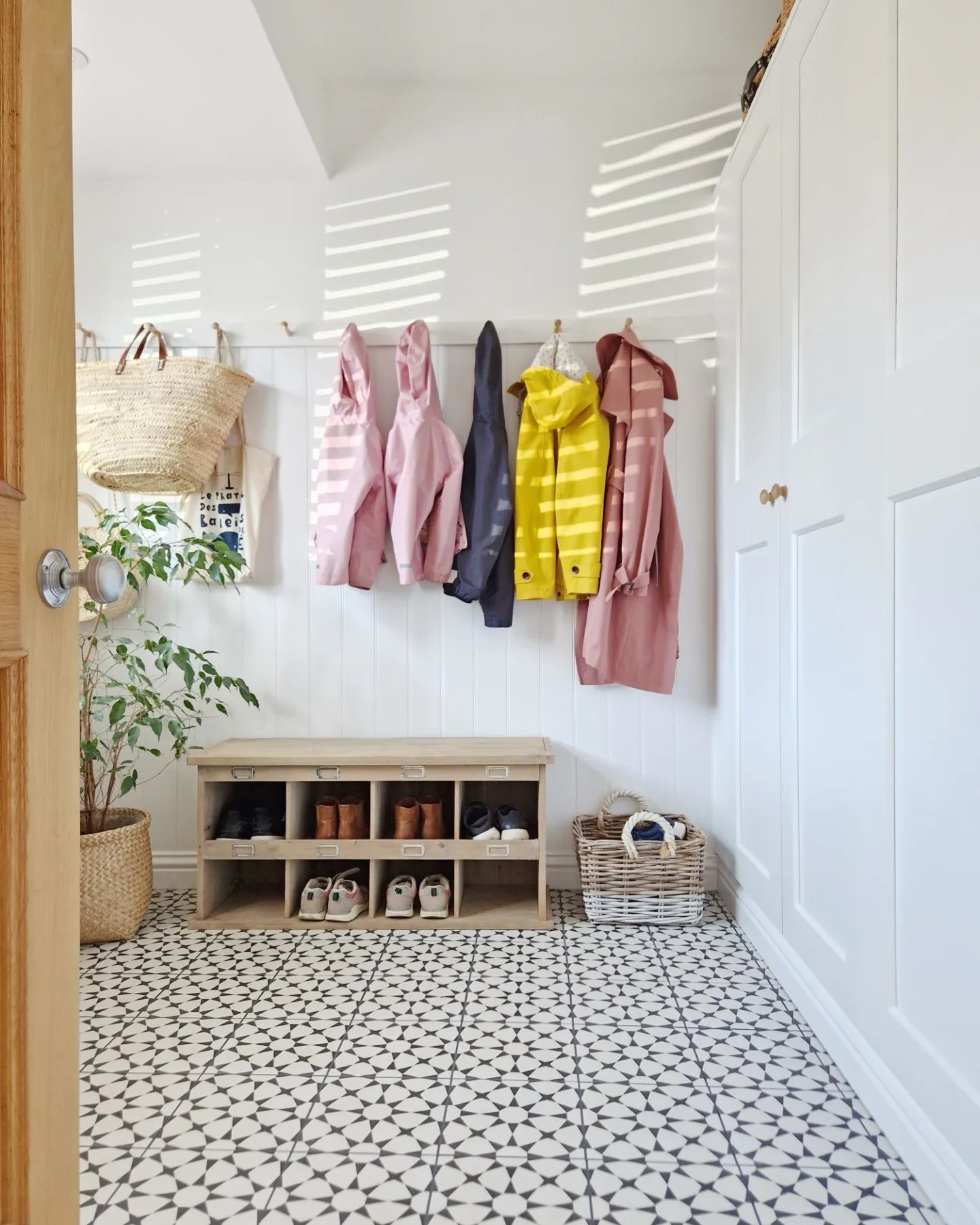 Front view of a mudroom with storage and hung-up jackets.