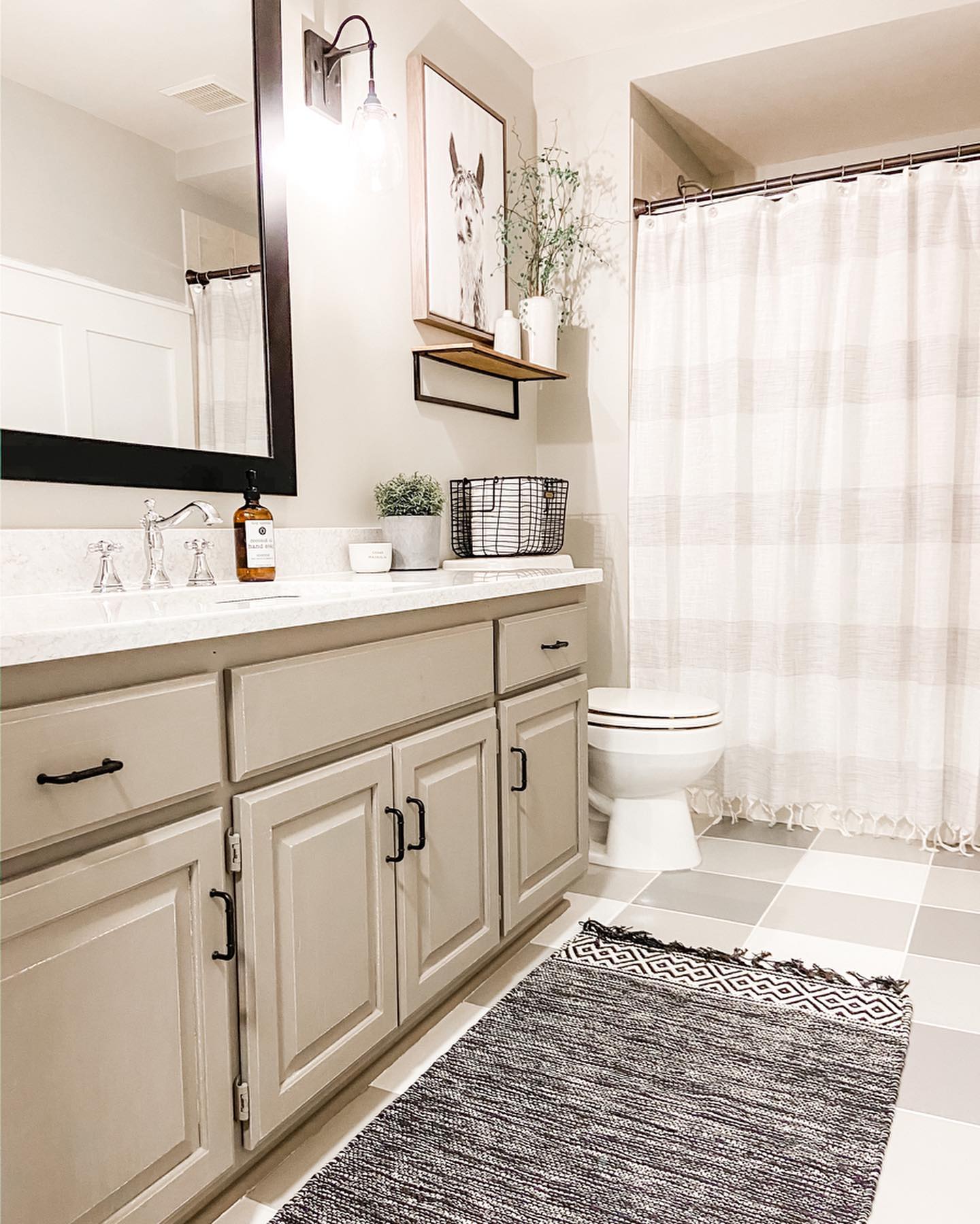 Basement bathroom with a shower, tile flooring, and neutral colors. Photo by instagram user @making_highview_home.