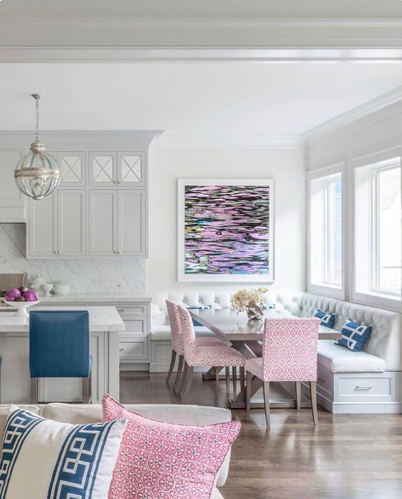 Depicted is a kitchen dining nook with pink chairs and windows behind. Photo by Instagram username @myblushcrush