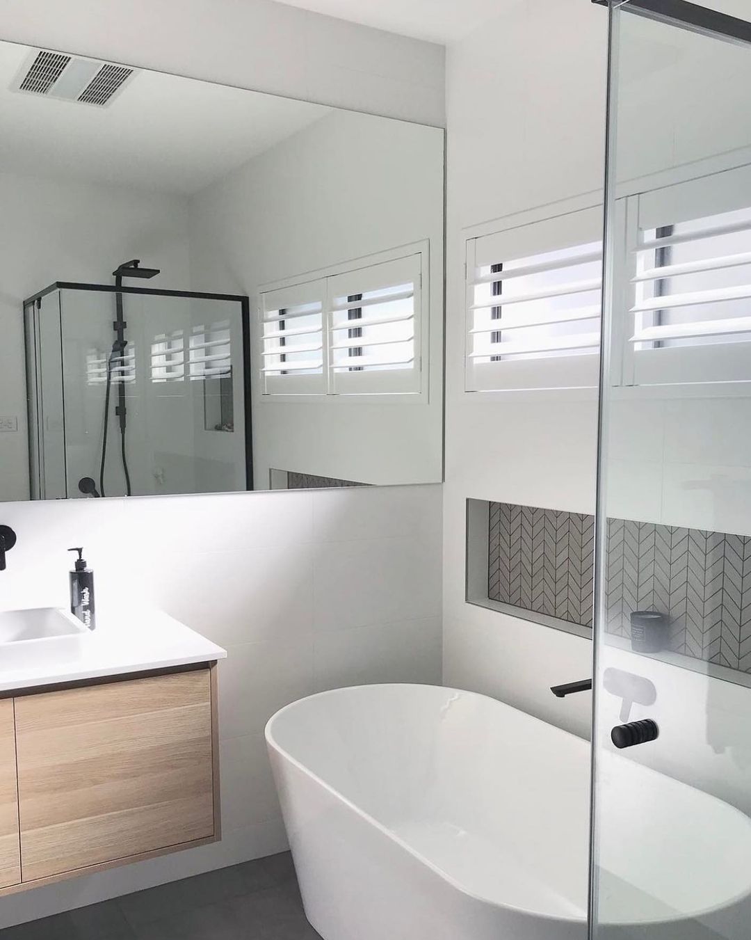 white modern bathroom with floating sink and bathtub. Photo by Instagram user @ventairfans