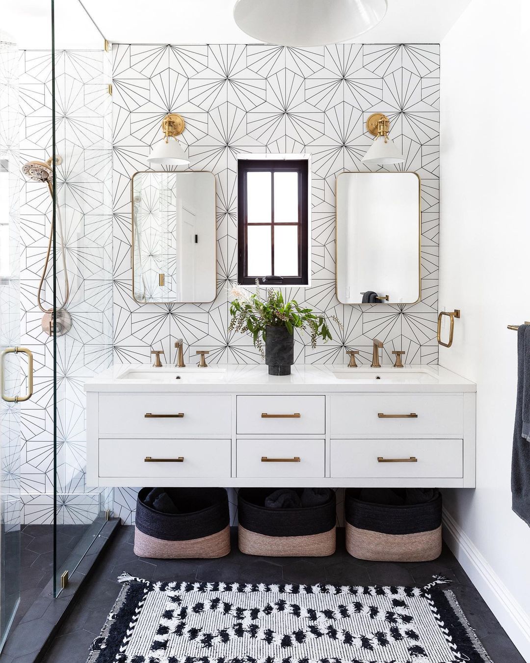 White floating vanity with double sinks and storage baskets. Photo by Instagram user @akerinteriors