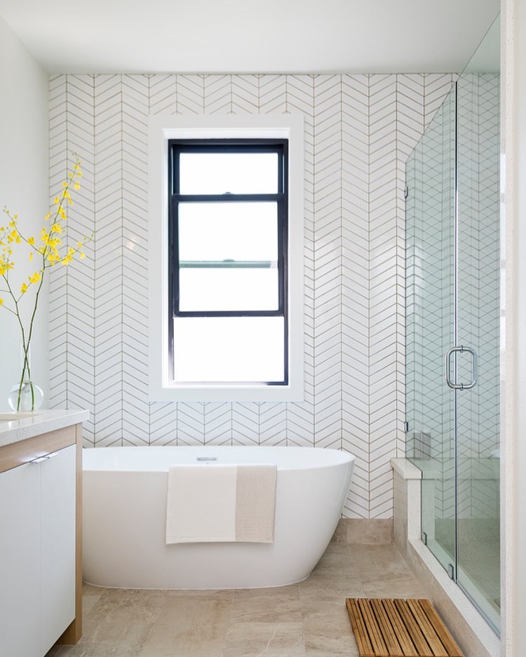 soaking tub in white bathroom with chevron wallpaper. Photo by Instagram user @dentondevelopments