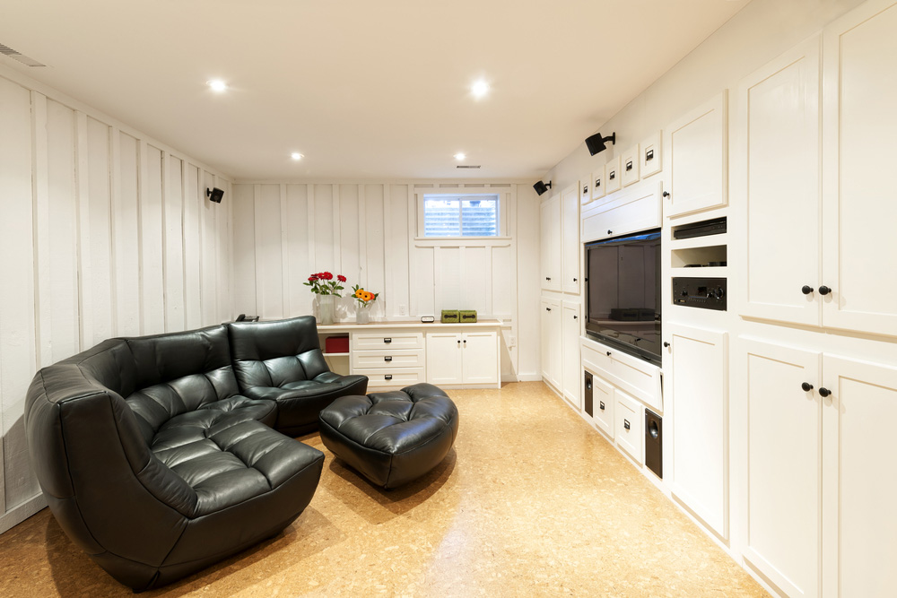 Renovated basement with built-in cabinets and wood-panneling.