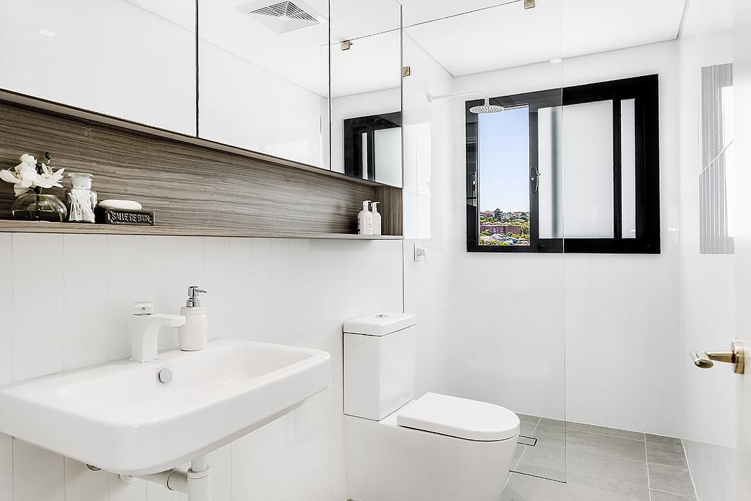 bathroom with white walls and gray tile floors with built in shelving photo by Instagram user @christopherjordanarchitecture