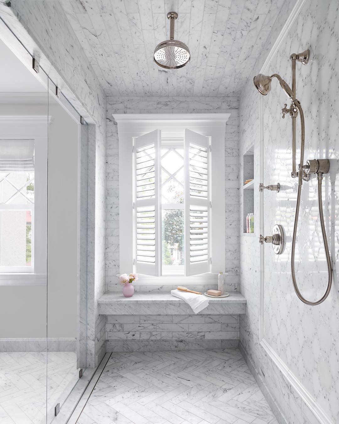 gray tile in large shower with shower bench and window photo by Instagram user @oakhillarchitects